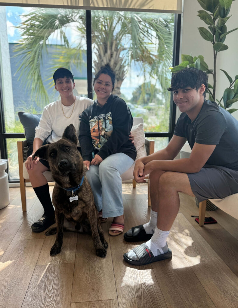 Family of 3. Murphy is a large brown dog with one floppy ear.