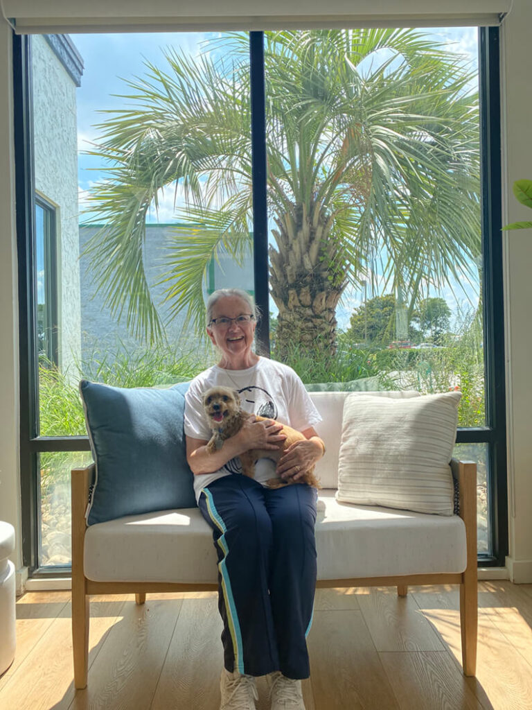 Single female holding small brown dog