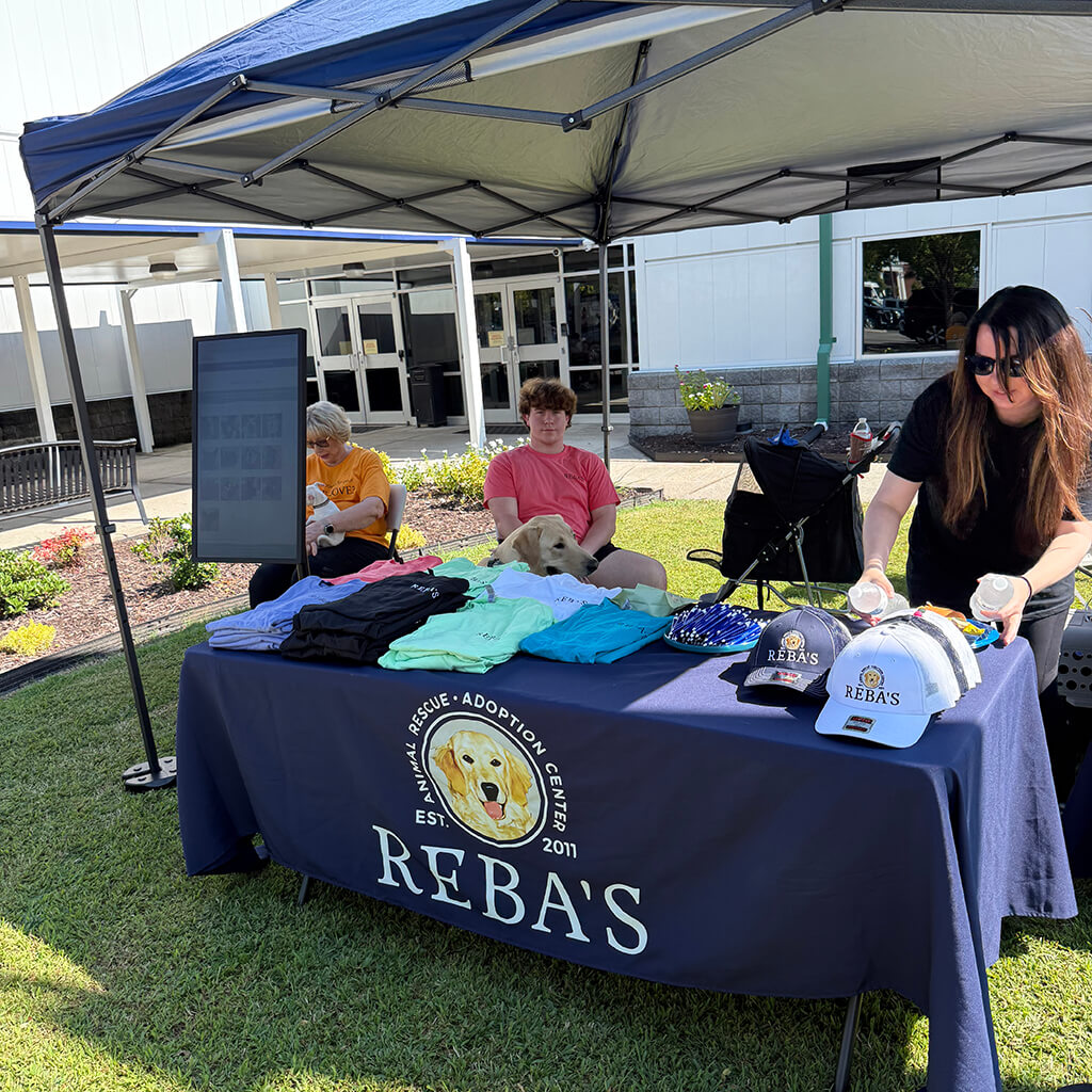 Rebas tent and table with 3 volunteers