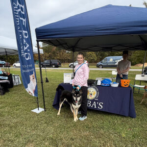 Reba's tent with employees and black dog in front