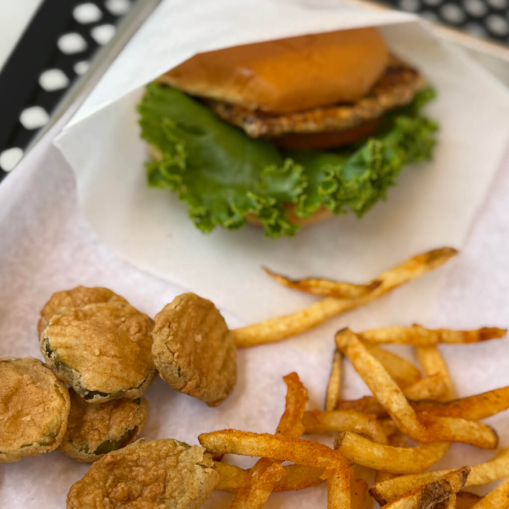 Tray of food including burger, pickle chips, and fries