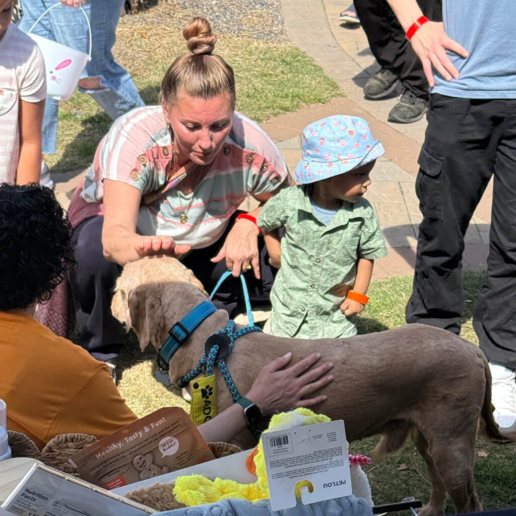 A mother and son pet the adoptable dog